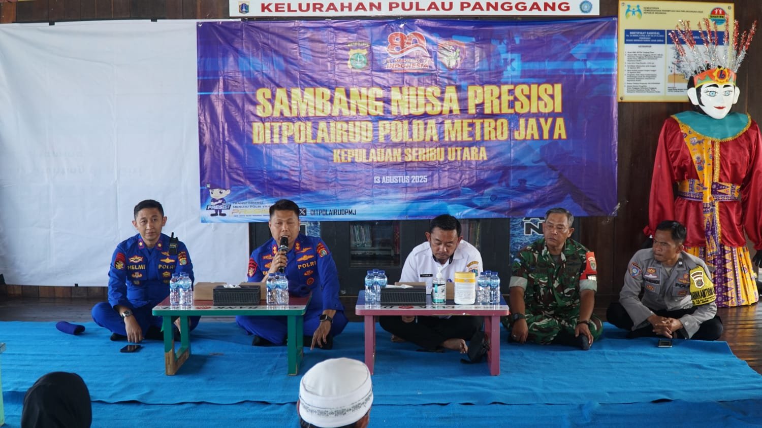 Wadir Polairud PMJ AKBP Bungin Masokan Misalayuk berbicara di depan warga Pulau Panggang saat Sambang Nusa Presisi 2025. <yoastmark class=